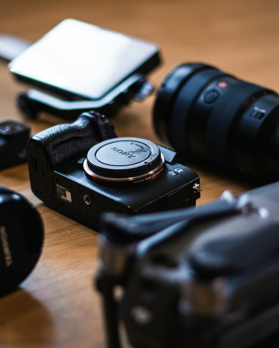Photography equipment including camera, lenses and a notebook on a table